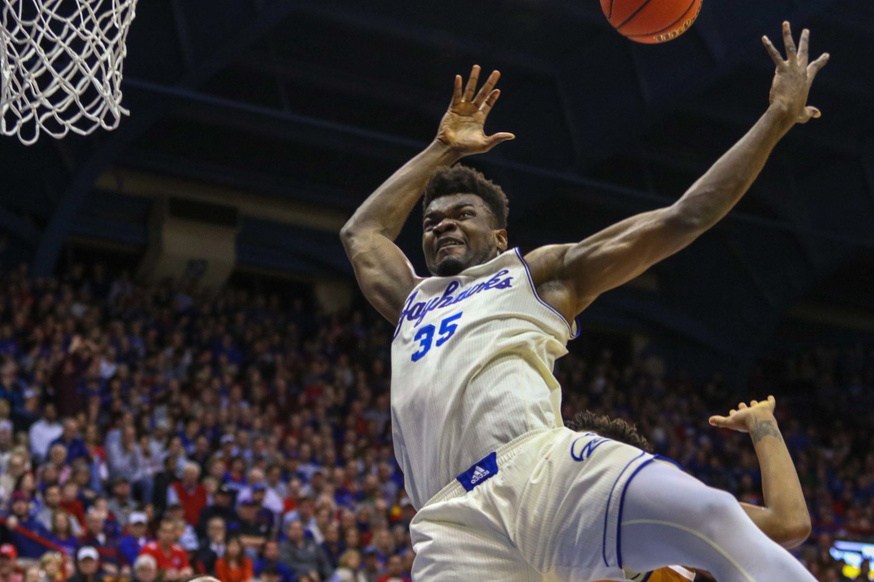 Senior center Udoka Azubuike jumps toward the basket and flails his arms to grab the ball